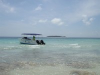 Dykbåt förbereds för en tur ut till reven kring Mnemba Island, som syns i bakgrunden. (Zanzibar, Tanzania)